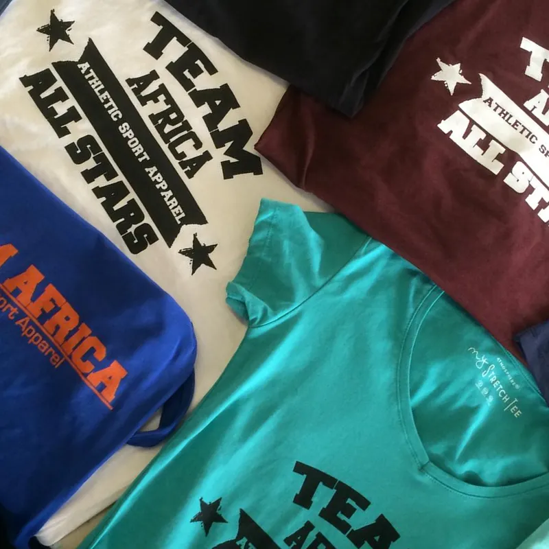 A group order of printed Team Africa T-shirts in teal, maroon, black, white and blue